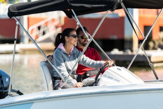 a man and woman driving their boat in Muskoka near Toronto Ontario